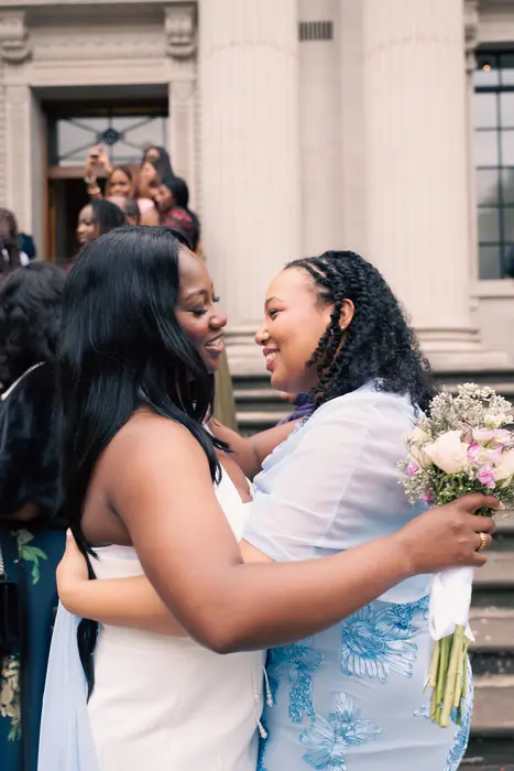 Bride hugging guests outside the wedding ceremony, photographed by Imisi Bamiro, Coventry photographer