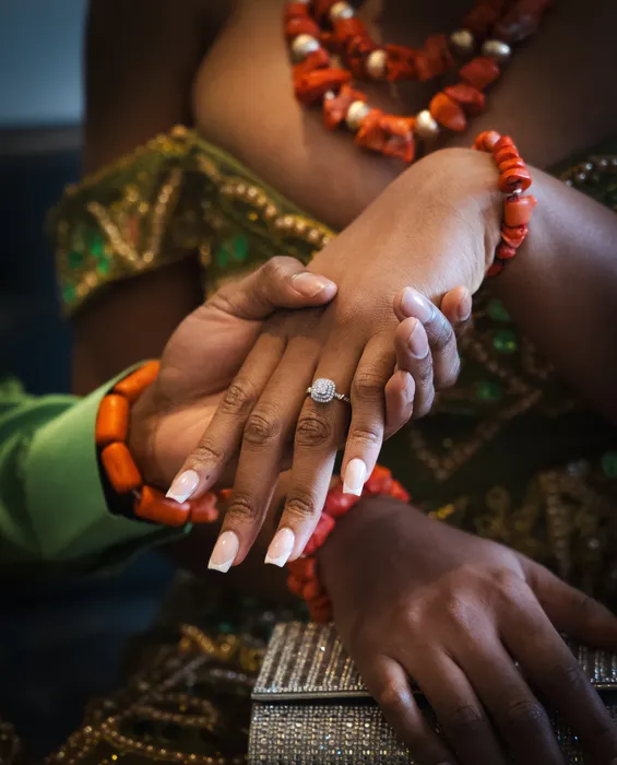 Close-up of hands with coral beads and an engagement ring, photographed by Imisi Bamiro, Coventry photographer
