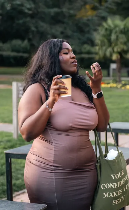 Lifestyle portrait of a woman in a nude dress outdoors, photographed by Imisi Bamiro, Coventry photographer