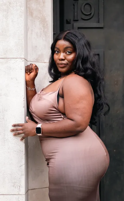 Lifestyle portrait of a woman in a nude dress outdoors, photographed by Imisi Bamiro, Coventry photographer