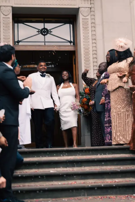 Newlyweds leaving the ceremony to cheers and confetti, photographed by Imisi Bamiro, Coventry photographer
