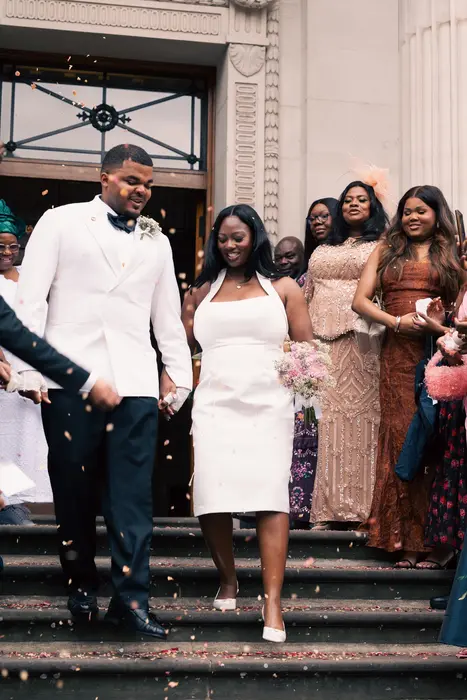 Newlyweds leaving the ceremony to cheers and confetti, photographed by Imisi Bamiro, Coventry photographer