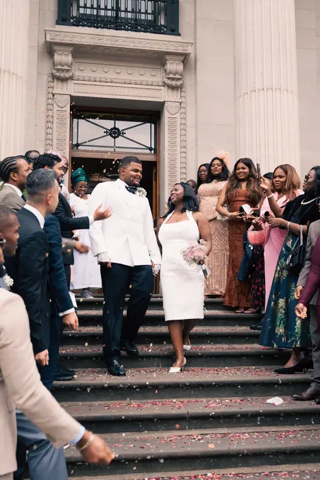 Newlyweds leaving the ceremony to cheers and confetti, photographed by Imisi Bamiro, Coventry photographer