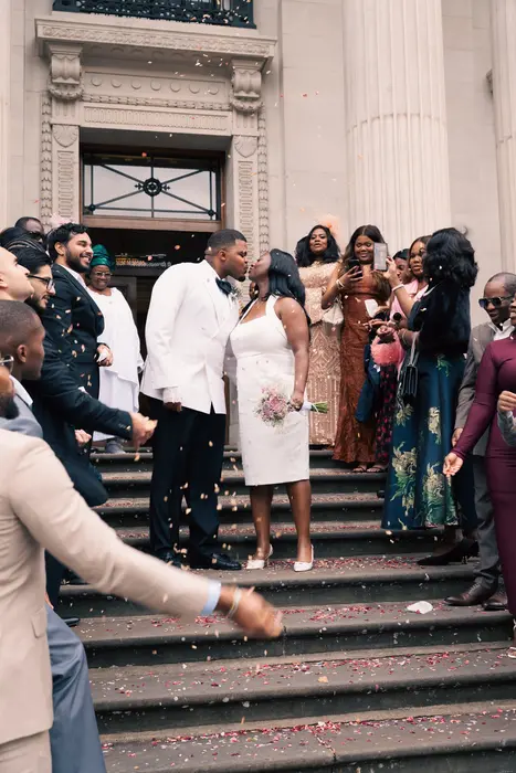 Newlyweds leaving the ceremony to cheers and confetti, photographed by Imisi Bamiro, Coventry photographer