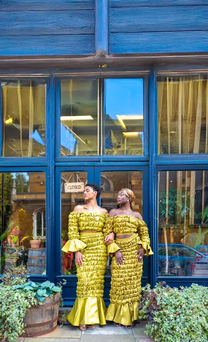 Two women in matching yellow outfits, photographed by Imisi Bamiro, Coventry photographer